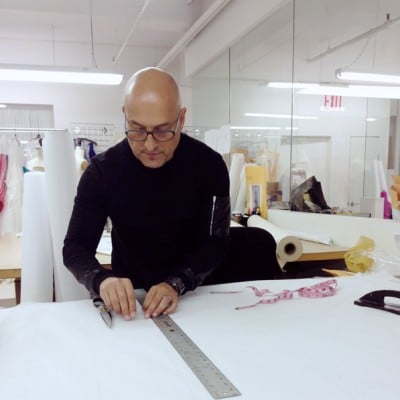 Before making a garment, Sanchez will sketch an idea, put together his ideal fabrics, and present the sketch to his team to create a canvas. Sanchez then cuts the fabric, drapes it over a mannequin, and moves to the table to transfer paper patterns. 