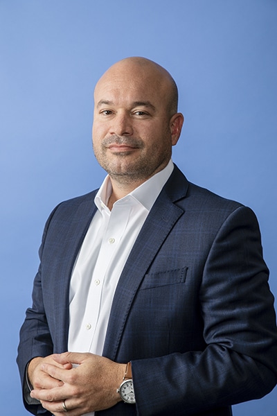 Ricardo Madan, TEKsystems, portrait blue background