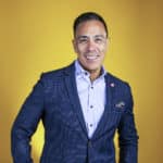 Guillermo Diaz, SVP of Customer Transformation, Cisco Systems, portrait yellow background