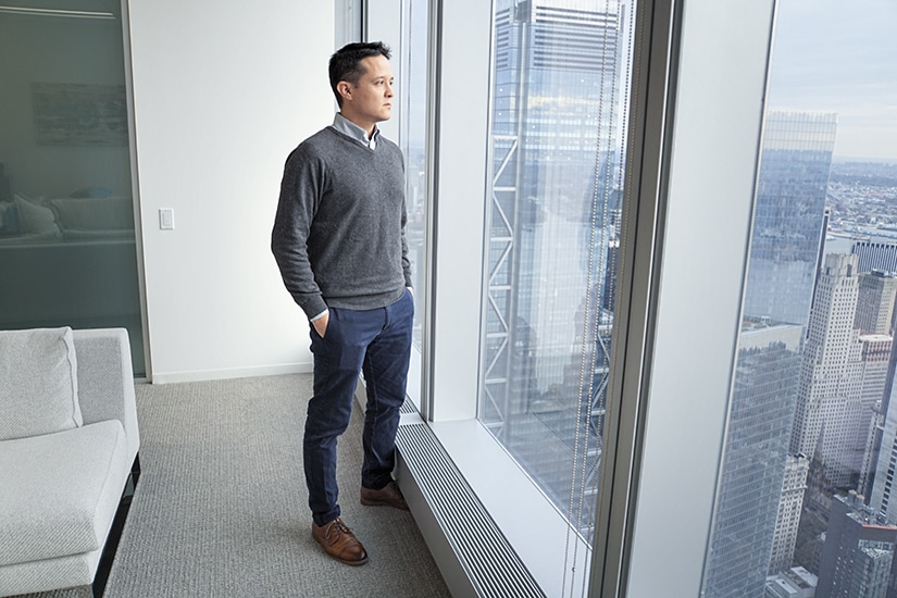 Alvaro Almanza, Kensho Technologies, looking out window of 76th floor office of Freedom Tower, Manhattan