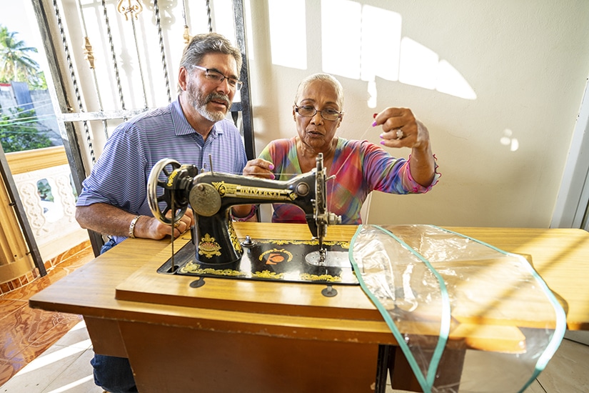 Albert Reyes and woman with sewing machine
