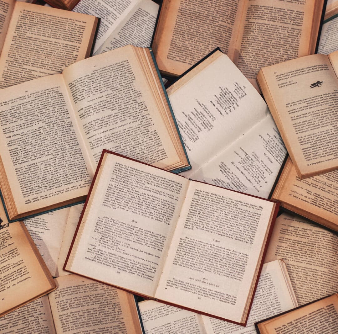 A collection of books open and laid out with their written words exposed