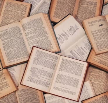 A collection of books open and laid out with their written words exposed