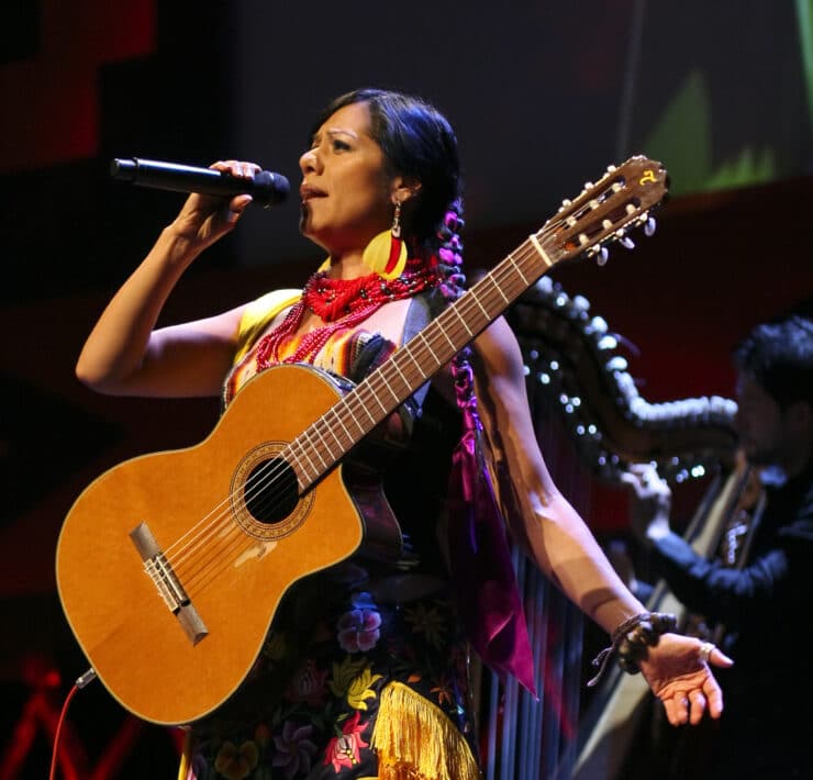 Mexican American singer-songwriter and activist Lila Downs sings with a guitar strapped to her chest