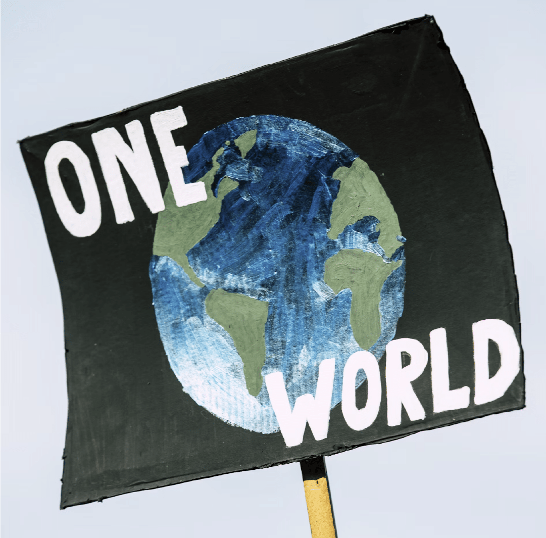 A picketing poster picturing the globe against a black background with the words "ONE WORLD" in white