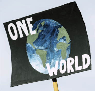 A picketing poster picturing the globe against a black background with the words "ONE WORLD" in white