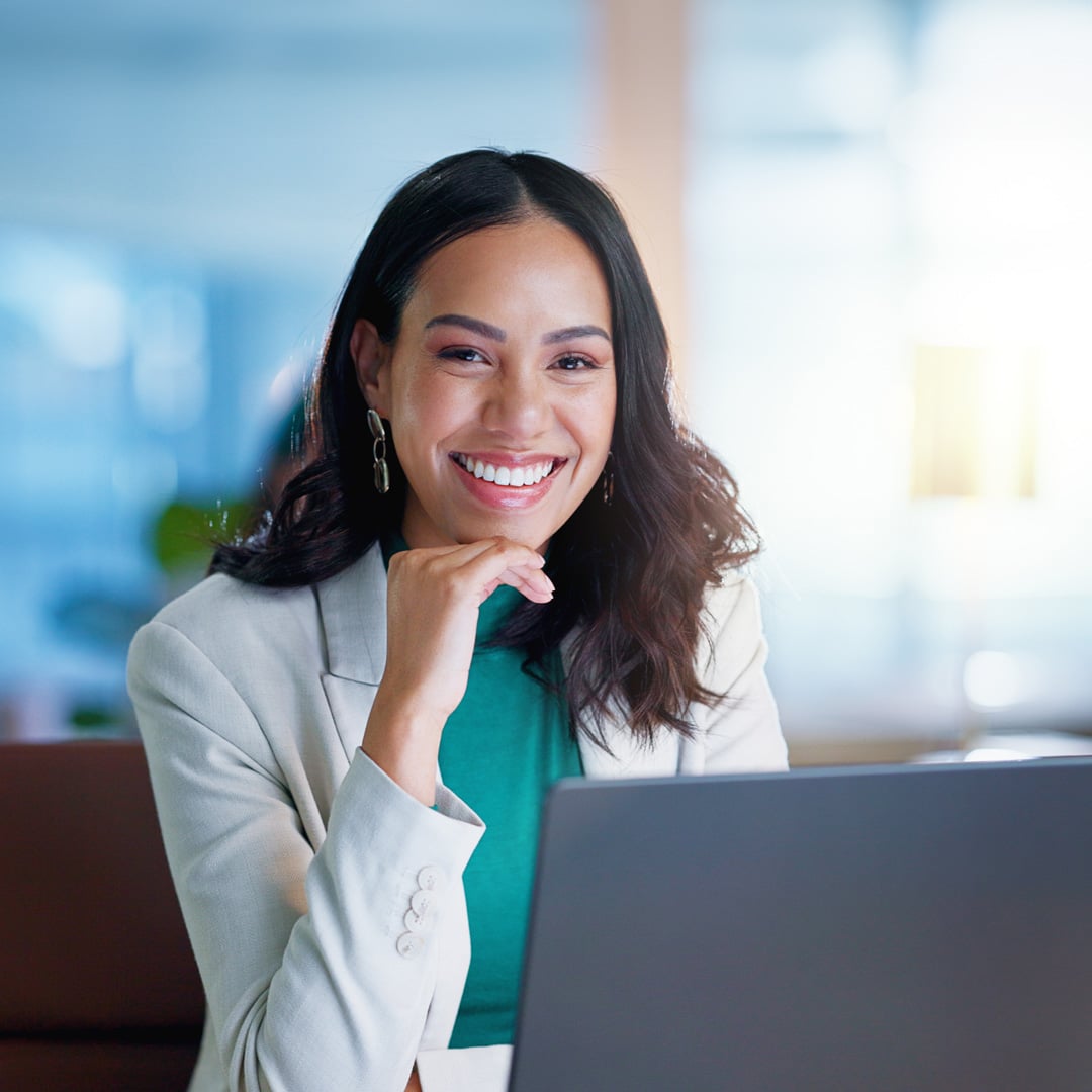 Woman smiling behind laptop