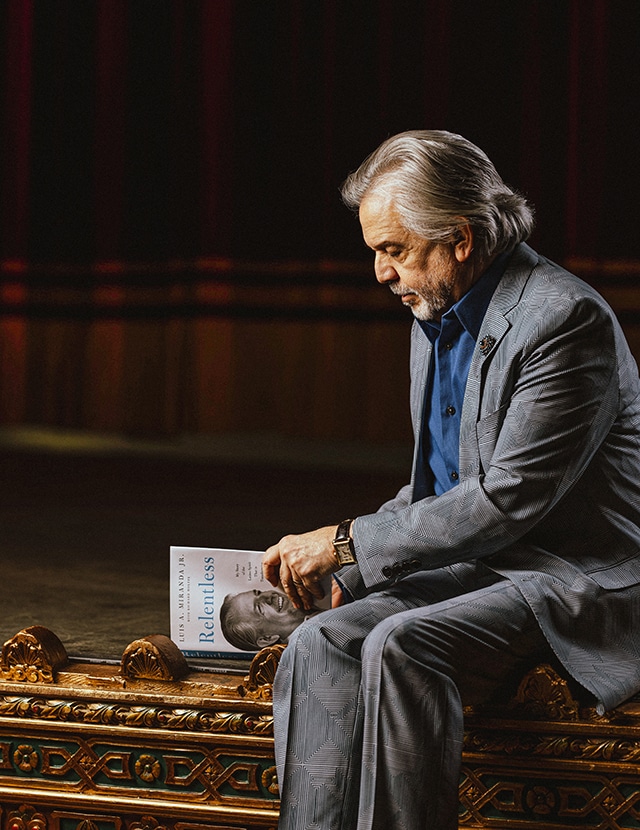 Luis A. Miranda Jr. looks at a copy of his memoir Relentless